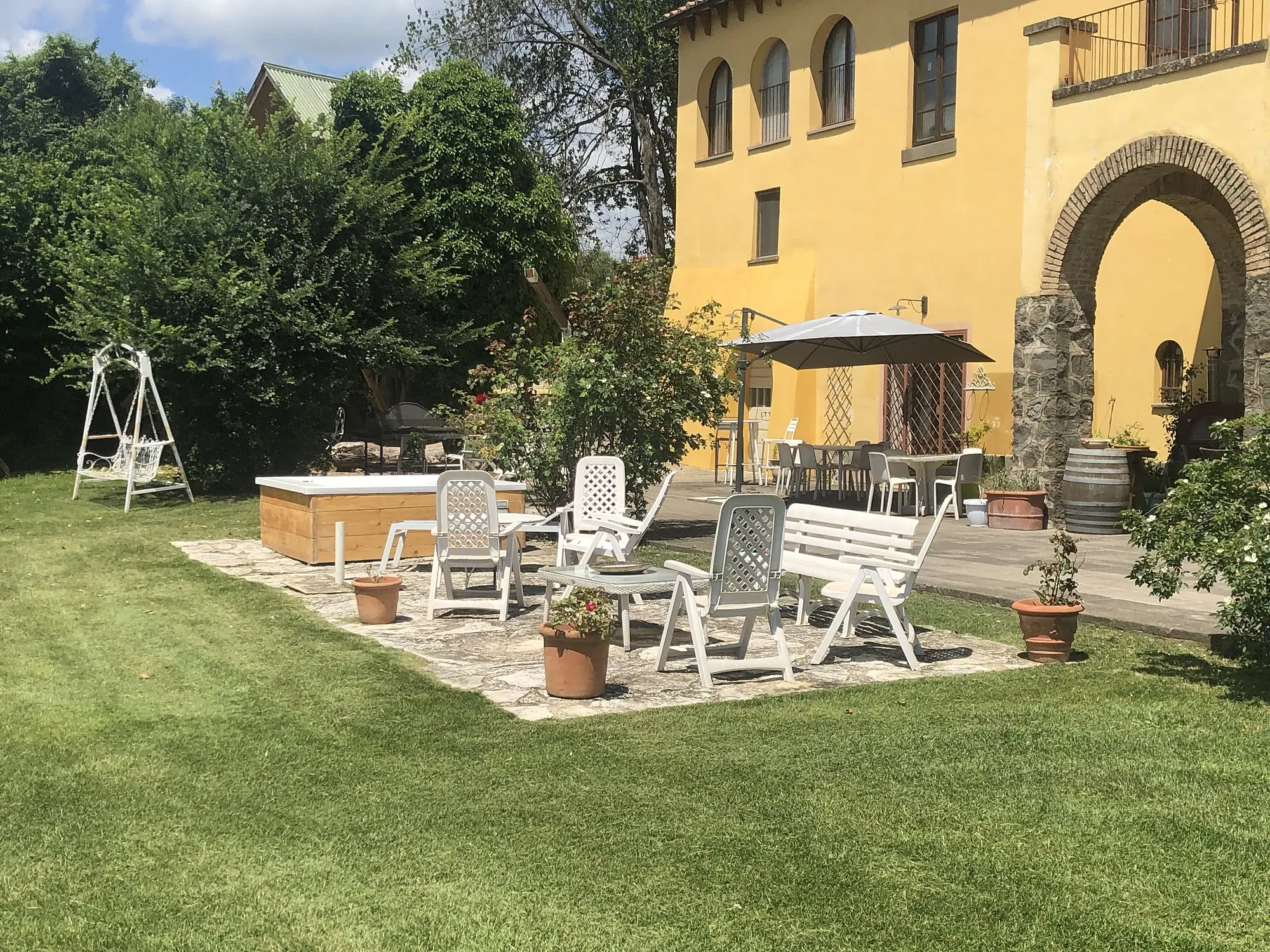 The garden of Casale Fedele with the Jacuzzi and the arched portico