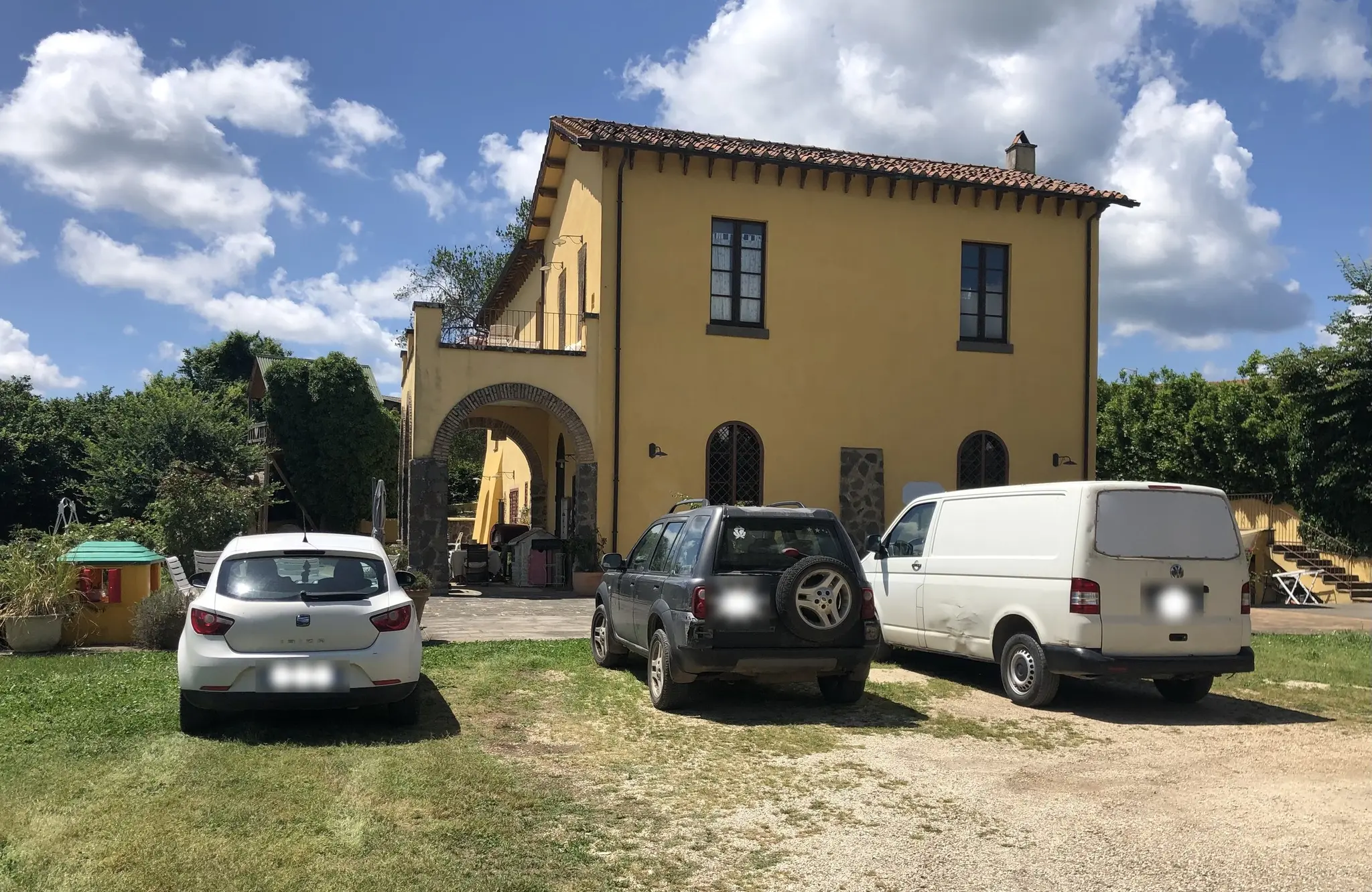 A van parked in front of the Casale, next to the cars