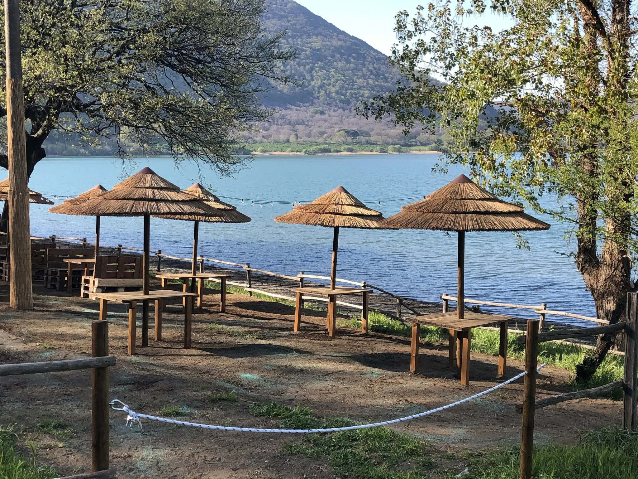 Straw parasols on the shore of Lake Vico