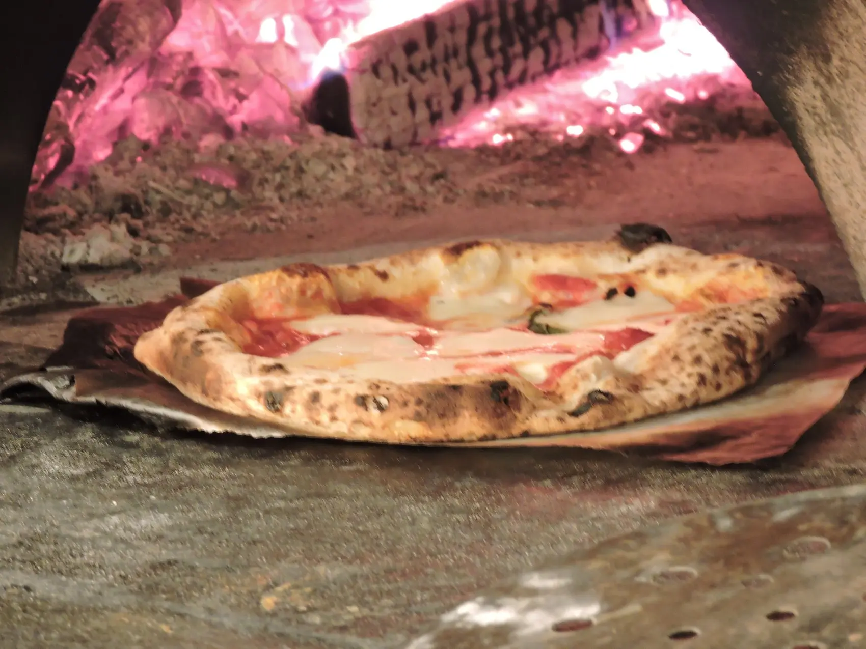 La pizza che cuoce nel forno a legna