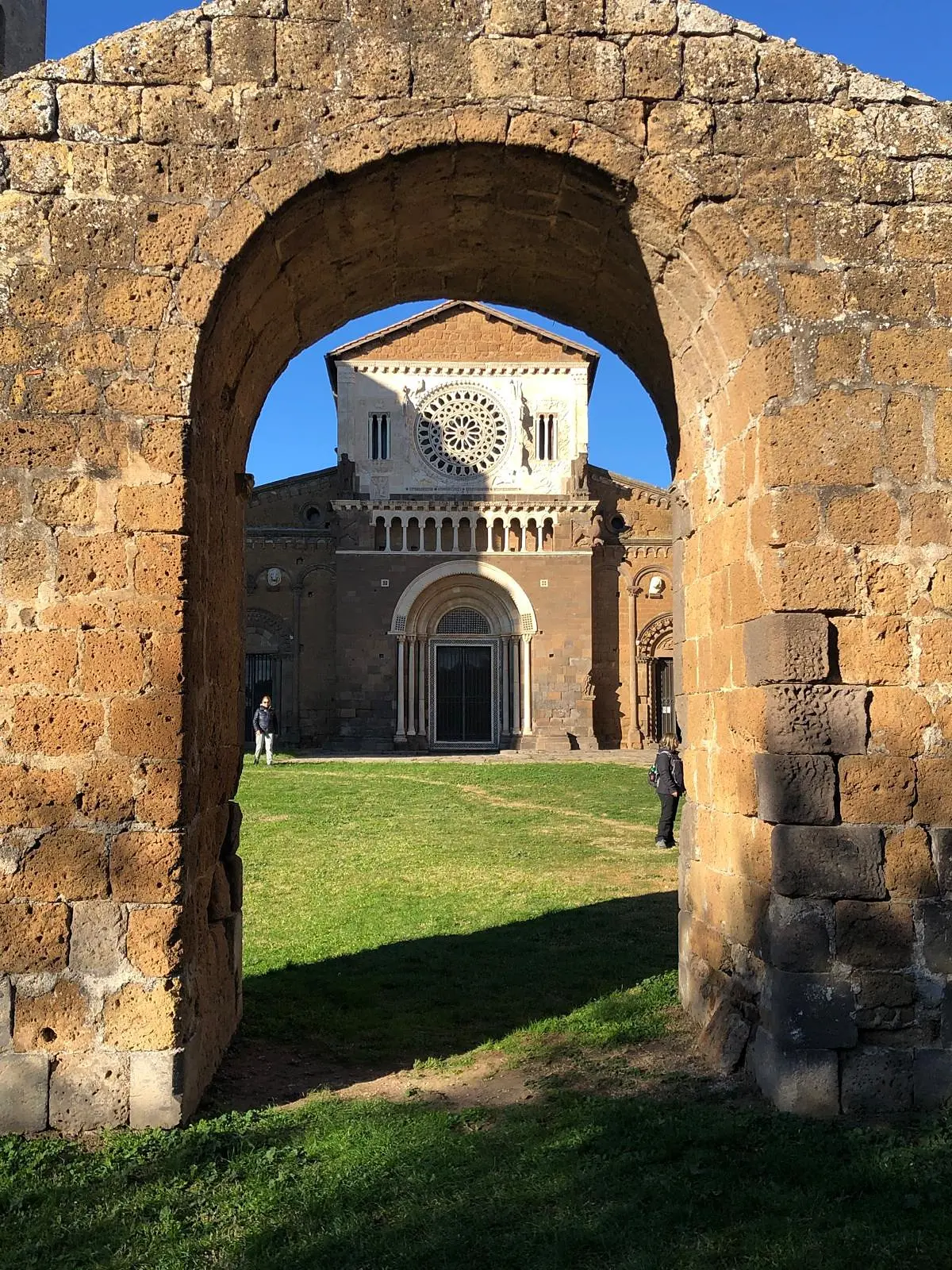 Tuscania: the basilica of San Pietro seen through an arch