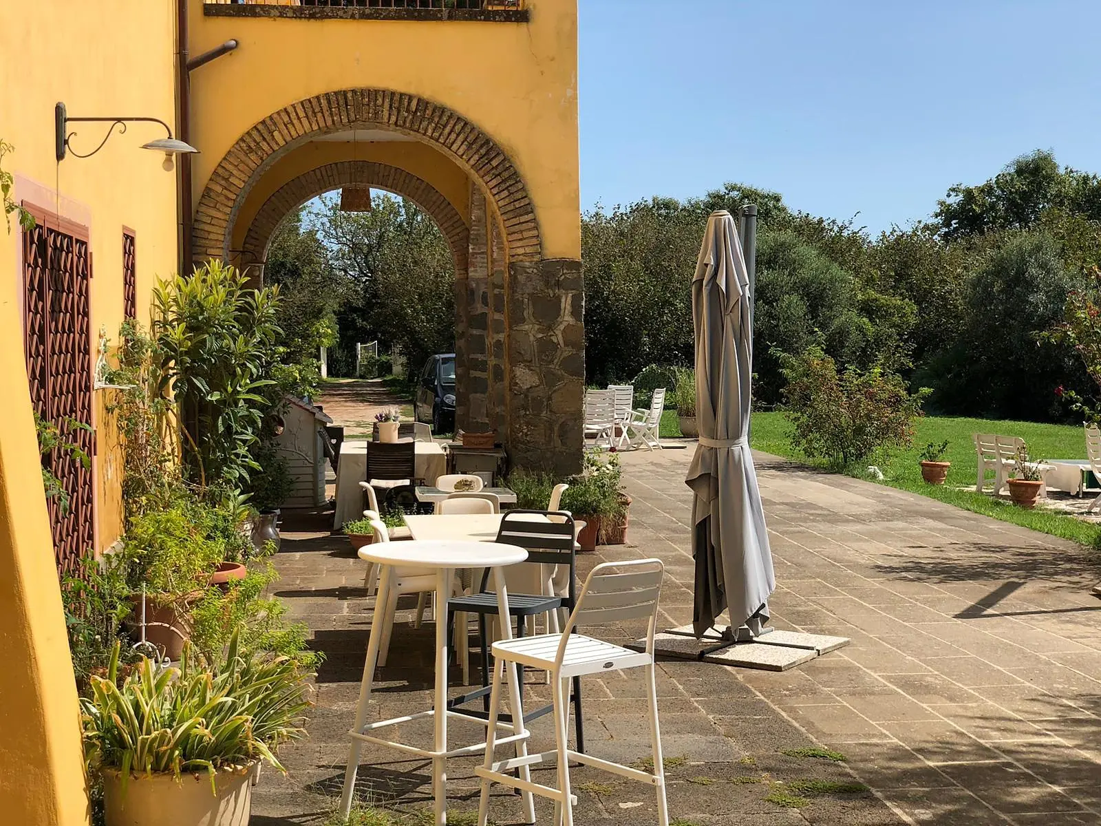 The paved terrace under the arch, with tables